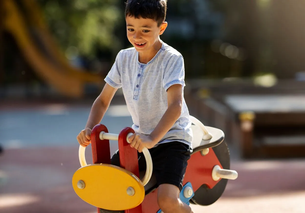 Children’s play area at Raymond Realty with colourful play structures and safe flooring.